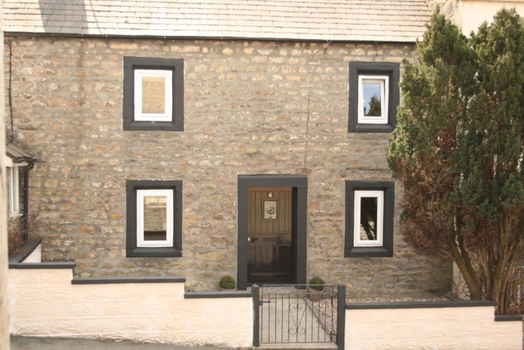 une maison en pierre avec des fenêtres noires et une porte dans l'établissement Our Holiday House Yorkshire , Bentham - Children and doggy friendly, à High Bentham