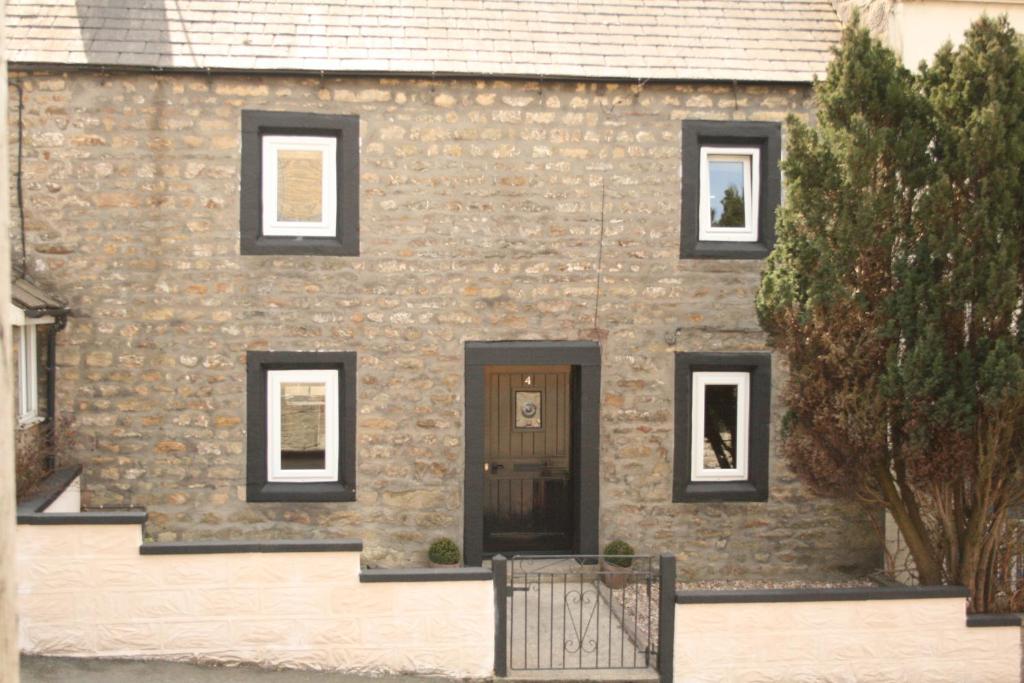 a stone house with black windows and a door at Our Holiday House Yorkshire , Bentham - Children and doggy friendly in High Bentham