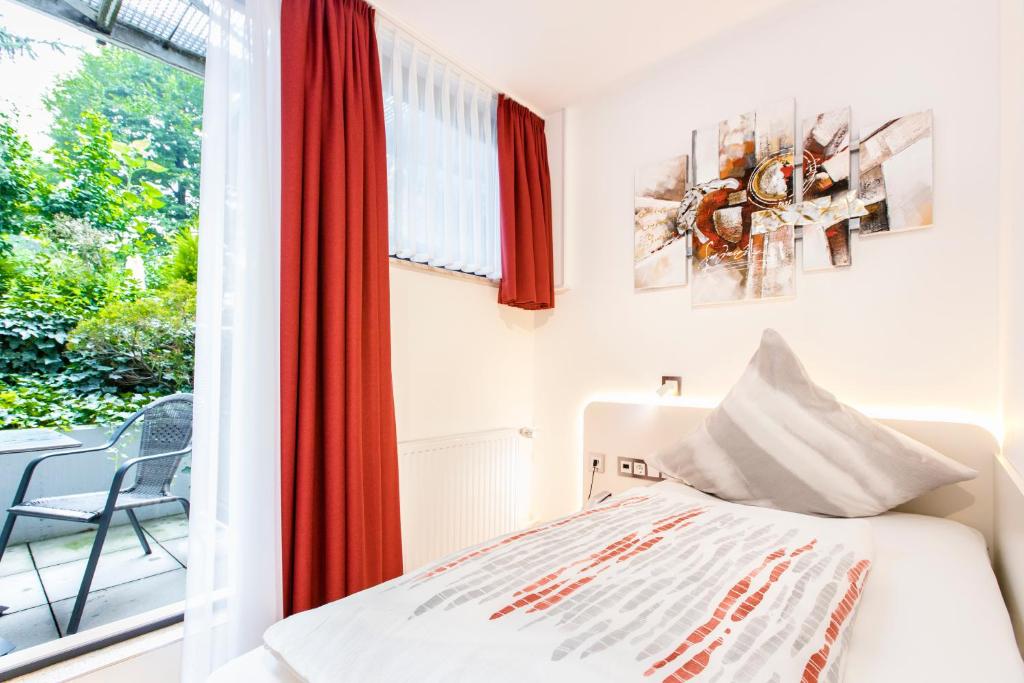 a bedroom with a bed and a window at Hotel Am Düsseldorfer Platz in Ratingen