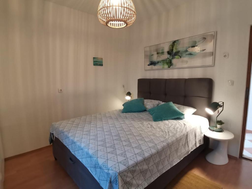 a bedroom with a bed with blue pillows on it at Zadar Apartman Kristijan in Zadar