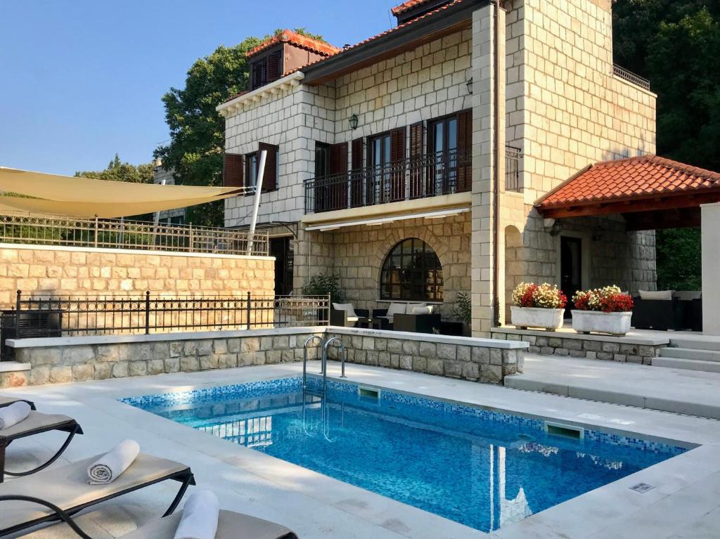 a house with a swimming pool in front of a house at Villa Franica in Dubrovnik