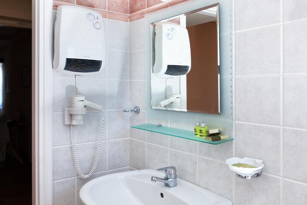 a bathroom with a sink and a mirror at Egli Hotel in Andros