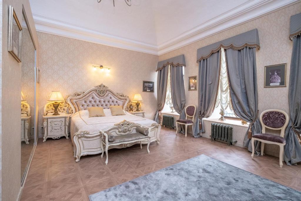 a bedroom with a white bed and two chairs at Отель-музей Казанский in Kazan