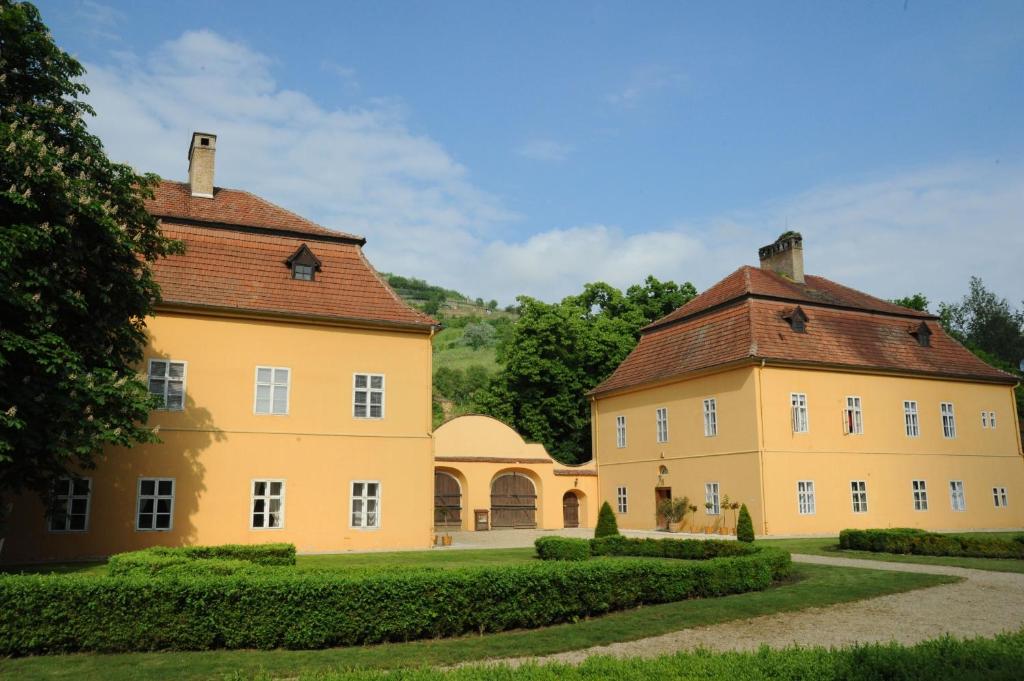 una gran casa amarilla con techo rojo en Rákóczi-Dessewffy Kastély Vendégház en Tokaj