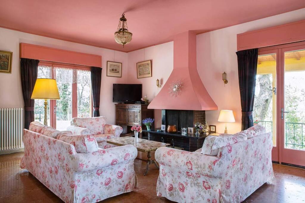 een woonkamer met 2 stoelen en een open haard bij Villa Belvedere-Con piscina a Bardolino in Costermano