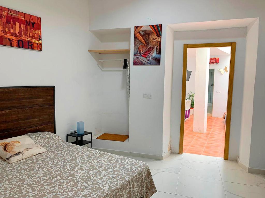 - une chambre avec un lit et une porte menant à un couloir dans l'établissement Nerja CityCenter Bajo, à Nerja