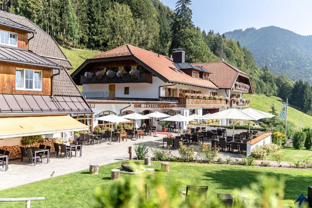 ein Hotel mit Tischen und Stühlen vor einem Gebäude in der Unterkunft Hotel Blaue Gams ***S in Ettal