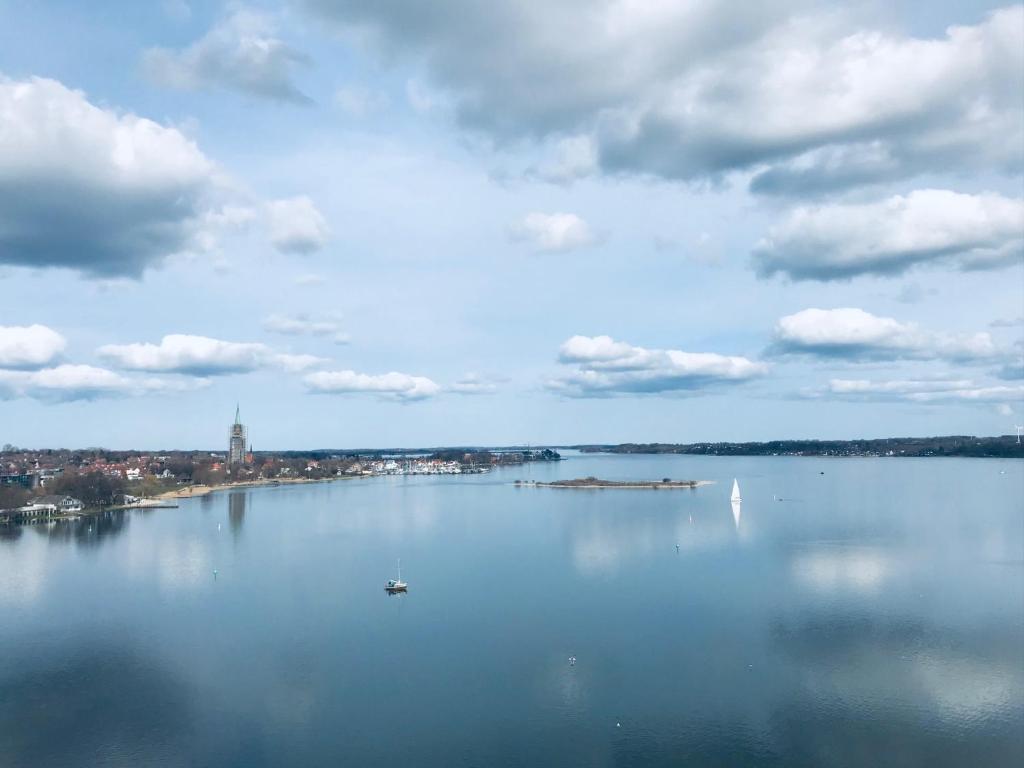 ein großer Wasserkörper mit einer Stadt in der Ferne in der Unterkunft Panoramablick Ostseefjord Schlei in Schleswig