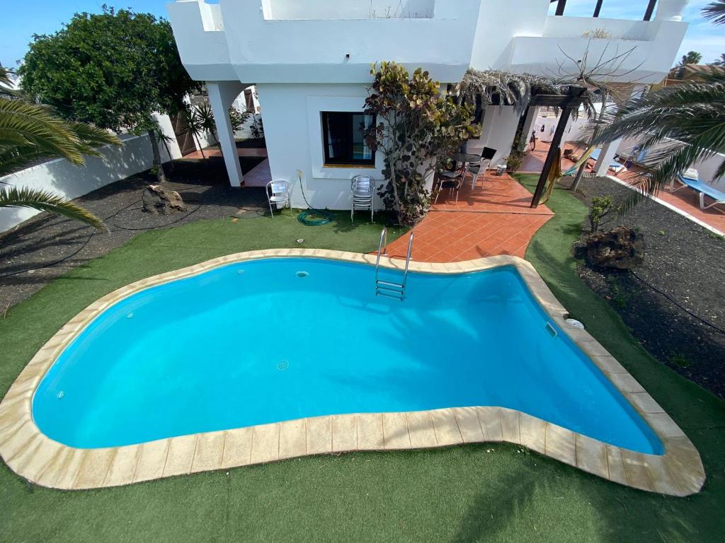 an overhead view of a swimming pool in front of a house at Royal Park Guesthouse in Corralejo