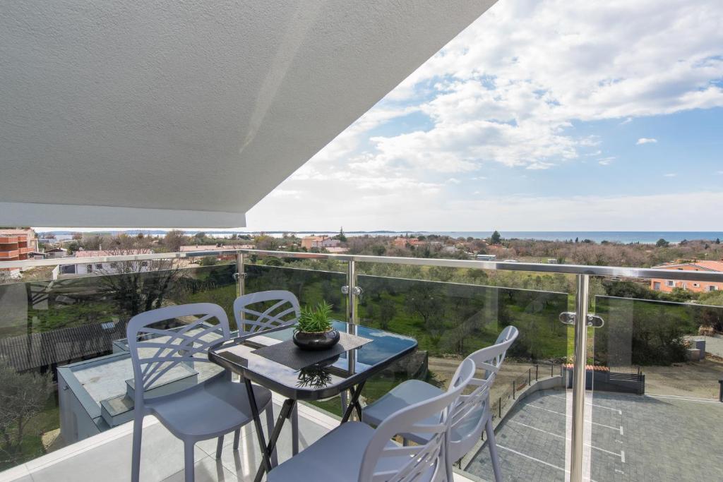 einen Balkon mit einem Tisch und Stühlen sowie Aussicht in der Unterkunft Apartment Serena, sea view, Peroj in Peroj