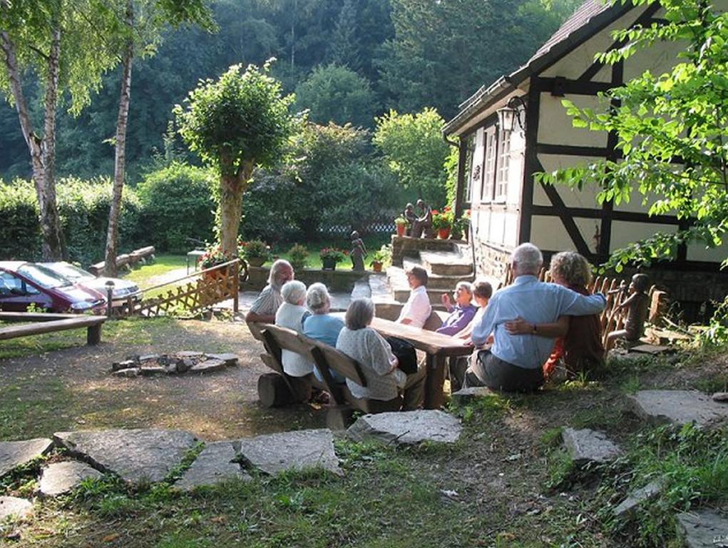 un grupo de personas sentadas en una mesa de picnic en Ferienhaus Jupp-Schöttler-Jugendherberge en Finnentrop