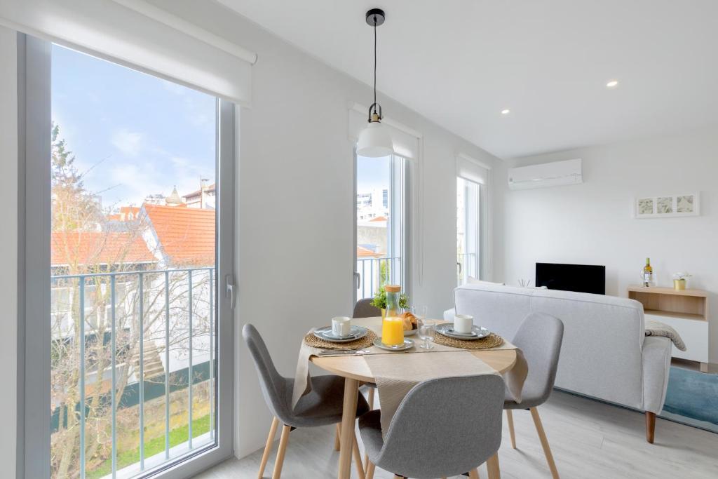 a dining room with a table and chairs and a large window at Vilar Charming Studio - Palácio de Cristal in Porto