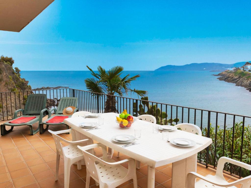 Biały stół i krzesła na balkonie z widokiem na ocean w obiekcie Apartment Cambre d'Aze by Interhome w mieście Llança