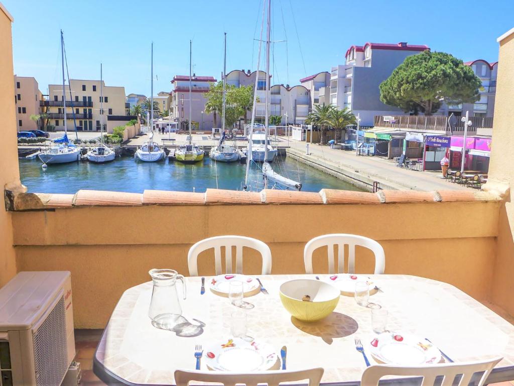 a table and chairs with a view of a marina at Apartment Les Méridiennes by Interhome in Gruissan