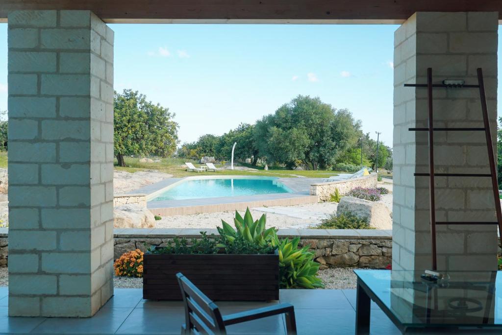 a patio with a view of a swimming pool at Le Cave di Fontane Bianche in Cassibile
