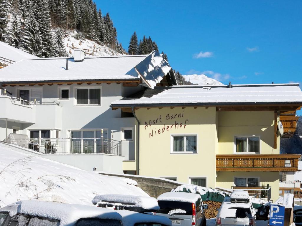 a snow covered building with cars parked in front of it at Holiday Home Apart Garni Niederhof - KPL119 by Interhome in Kappl