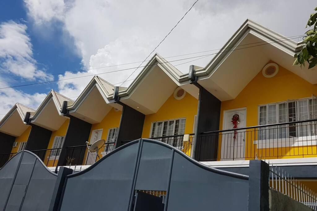 une maison jaune avec une rampe devant elle dans l'établissement Diodeths Holiday Apartment, à Butuan