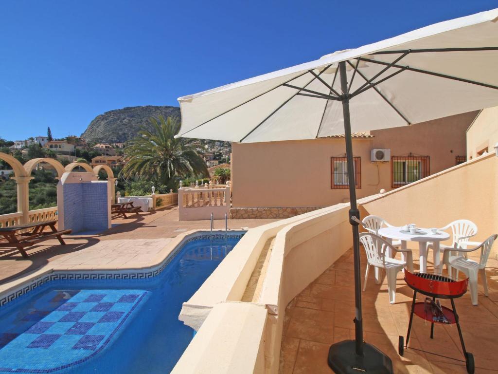 un patio con mesa y sombrilla junto a la piscina en Apartment Canuta Baja 7 by Interhome en Calpe