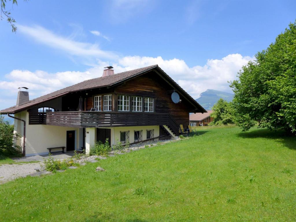 een groot houten huis met een groot grasveld bij Chalet Panoramablick by Interhome in Aeschi