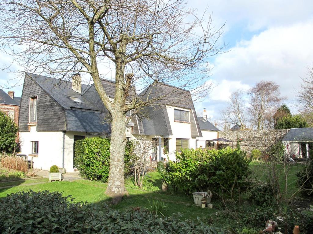 une maison blanche avec un arbre dans la cour dans l'établissement Holiday Home Entre mer et jardin - PPT401 by Interhome, à Saint-Pierre-en-Port