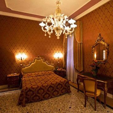 a bedroom with a bed and a chandelier at Residenza Hotel San Maurizio in Venice