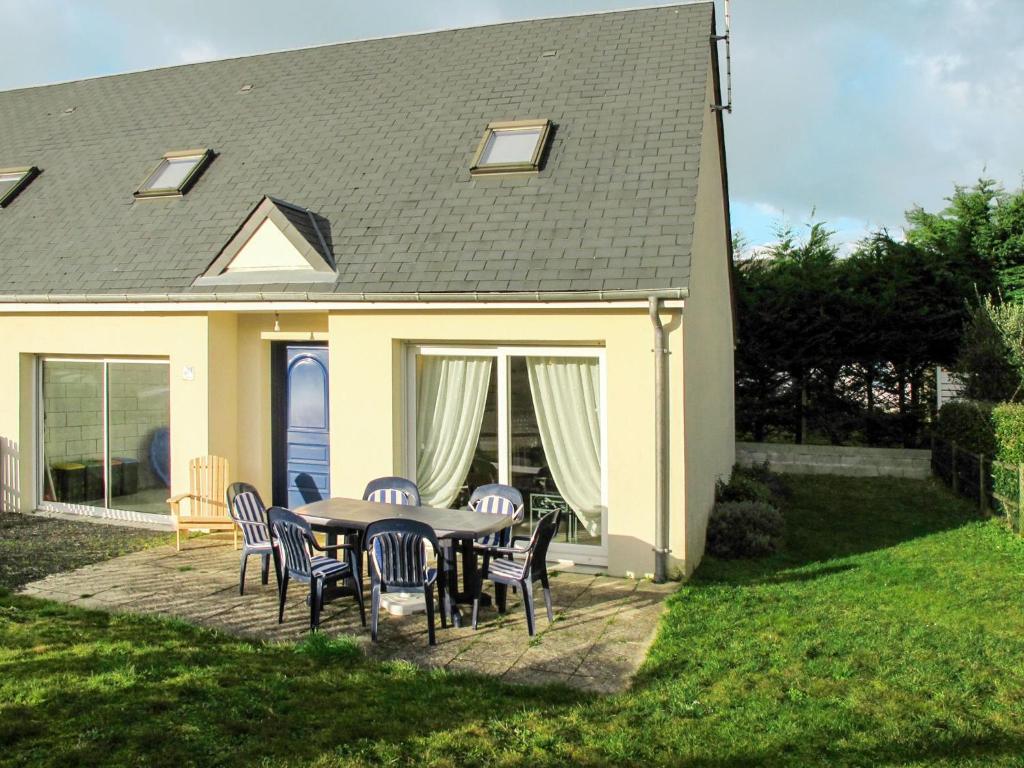 un patio con mesa y sillas frente a una casa en Holiday Home Néroli - HSM200 by Interhome, en Hauteville-sur-Mer