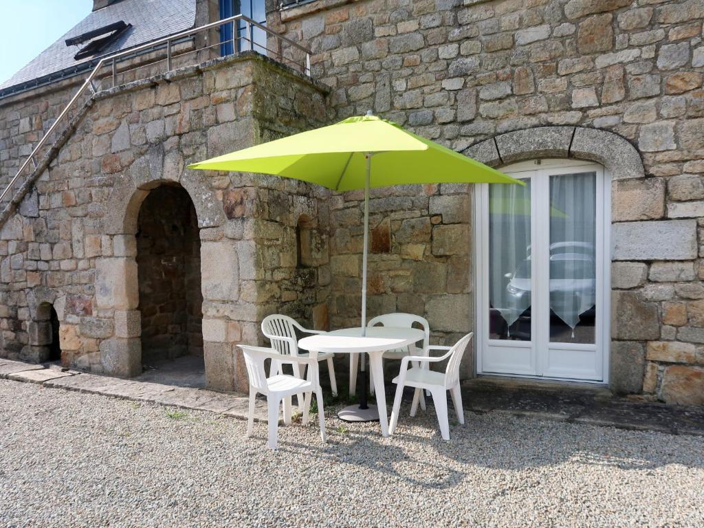 une table avec deux chaises et un parapluie jaune dans l'établissement Holiday Home Houat by Interhome, à Plouhinec