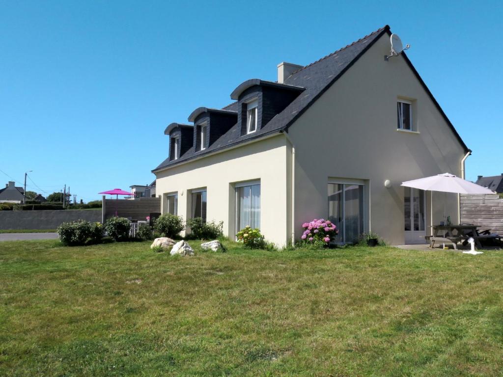ル・コンケにあるHoliday Home Mer d'Iroise 2 - LCQ105 by Interhomeの芝生の上に傘を置いた白い家
