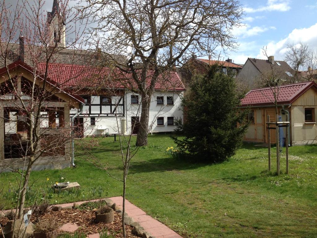 a large white house with a tree in the yard at Ferienhaus am Rosslauer Markt in Dessau