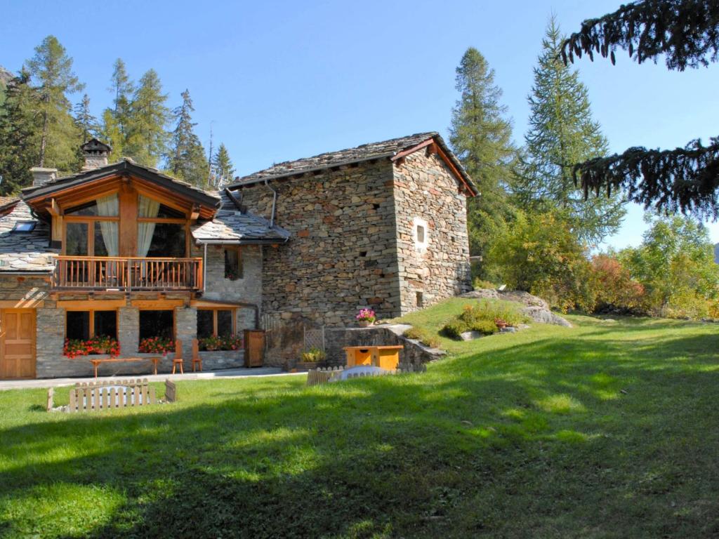 a large stone house with a balcony on a lawn at Chalet Chez Les Roset by Interhome in Baulen