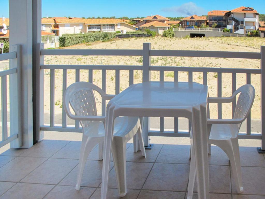 una mesa y 2 sillas en un balcón con vistas a la playa en Apartment Résidence Belle Dune - BPL331 by Interhome, en Biscarrosse-Plage