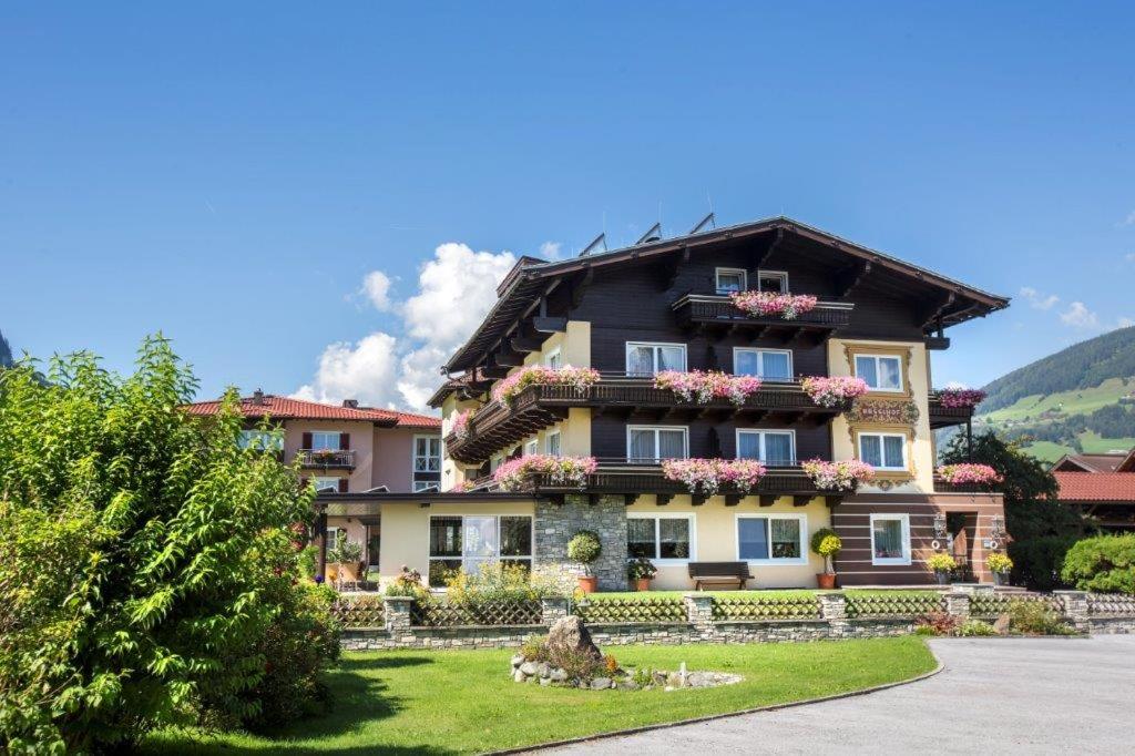 ein großes Haus mit Blumen auf der Vorderseite in der Unterkunft Garni Rösslhof in Hollersbach im Pinzgau