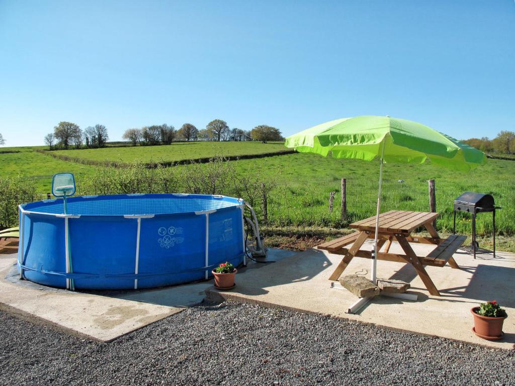 bañera de hidromasaje y mesa de picnic con sombrilla verde en Holiday Home Les Brûles - BTR300 by Interhome, en Ternant