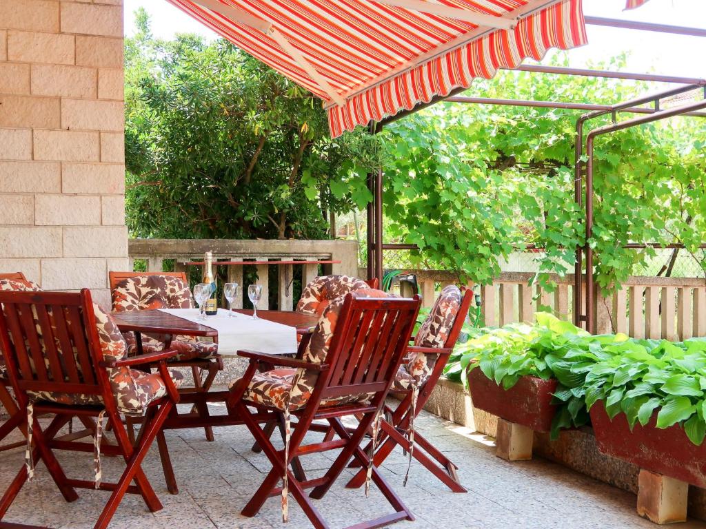 a table and chairs under an umbrella on a patio at Apartment Vesna - PUT106 by Interhome in Punat