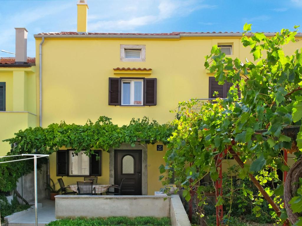 a yellow house with a bunch of vines at Holiday Home Antica - PUT103 by Interhome in Punat