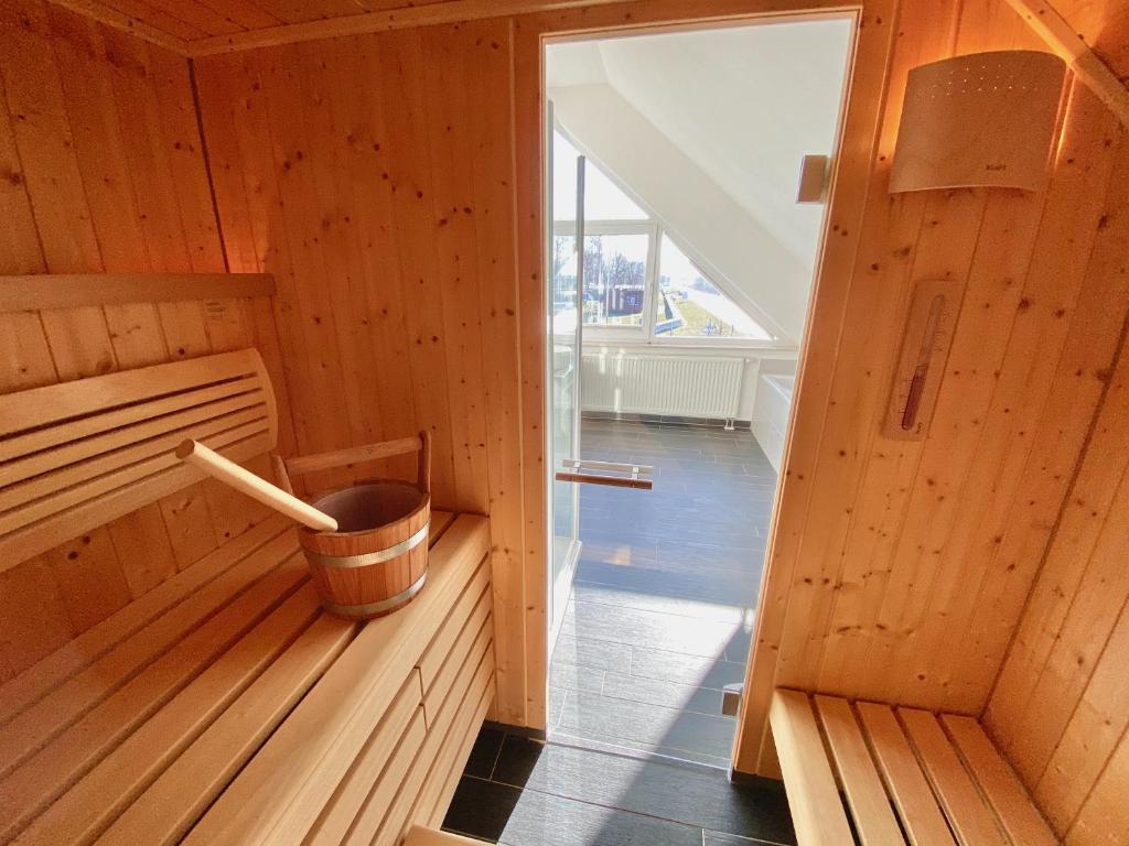 a small wooden sauna with a bucket in it at mönchgut living & spa in Gager