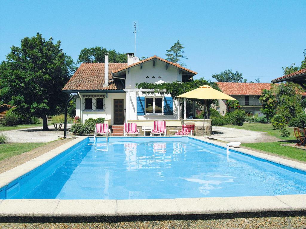 una piscina con sillas y una sombrilla frente a una casa en Holiday Home Le Belon - MOS140 by Interhome, en Mézos