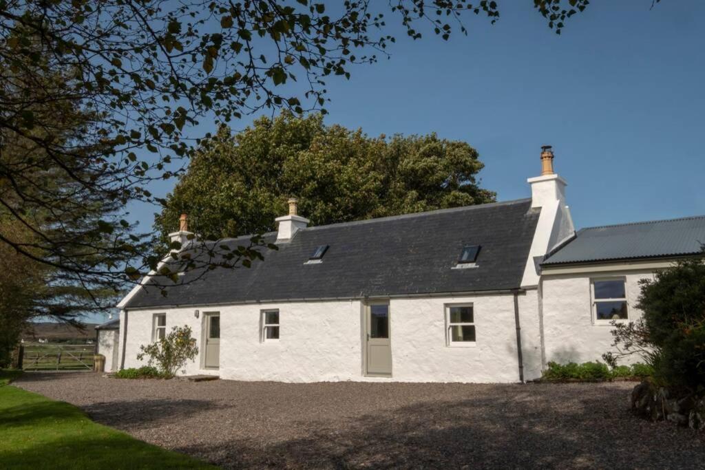 a white house with a black roof at Portree, Isle of Skye in Portree