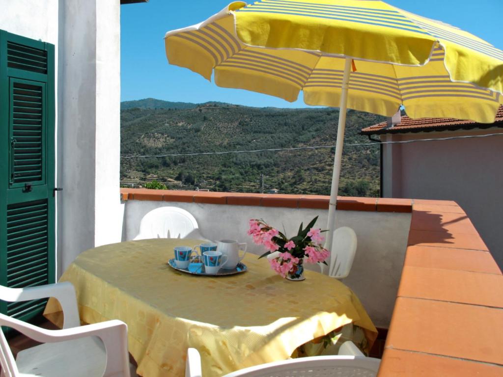 Costa CarnaraにあるApartment Marisa - DOL126 by Interhomeのバルコニーに黄色い傘と花を飾ったテーブル