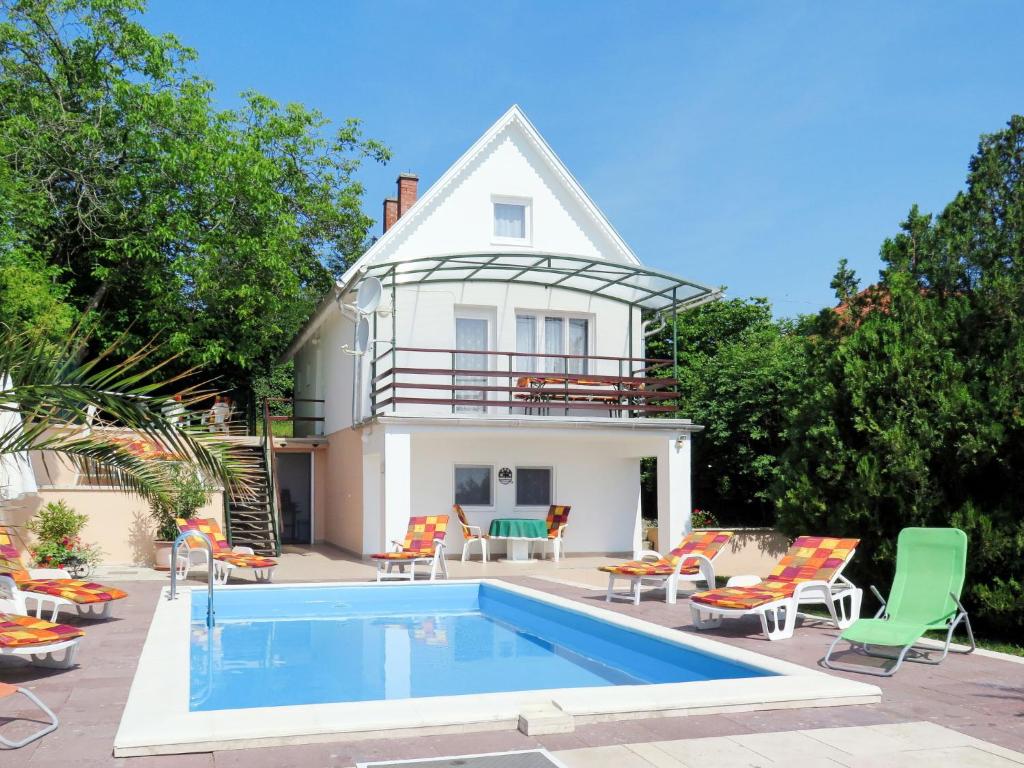 a house with a swimming pool in front of a house at Holiday Home Annemarie - ALD317 by Interhome in Balatonalmádi