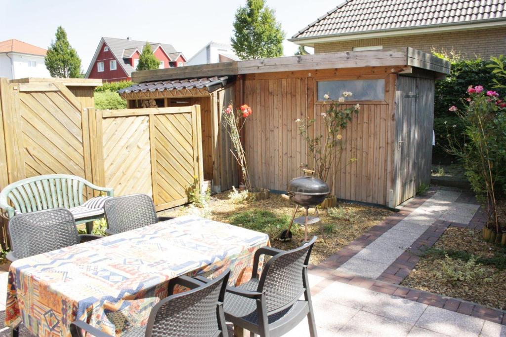 a backyard with a table and chairs and a grill at fewo1846 - Ueber der Foerde - komfortables Reihenhaus mit Garten und Carport in Flensburg