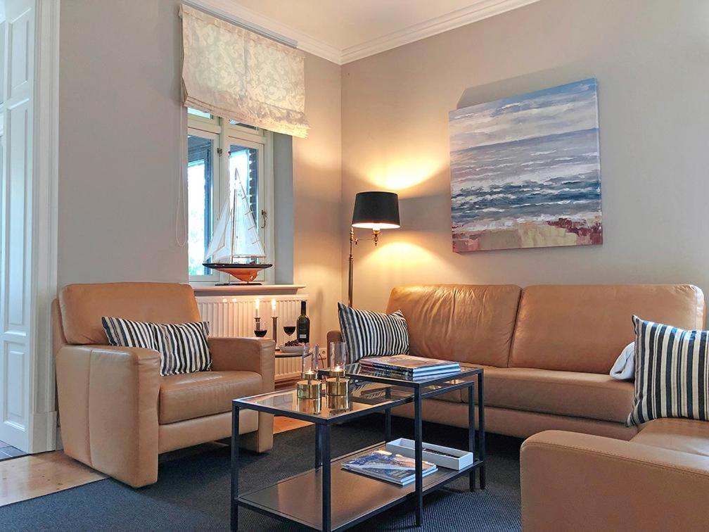 uma sala de estar com um sofá e uma mesa em fewo1846 - Heimathafen Flensburg - Luxuriöse Stadtvilla mit 3 Schlafzimmern und großem Grundstück em Flensburg