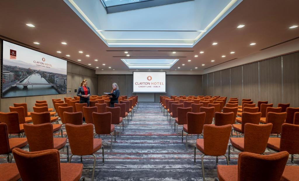 una sala conferenze con sedie e due persone sullo schermo di Clayton Hotel Cardiff Lane a Dublino