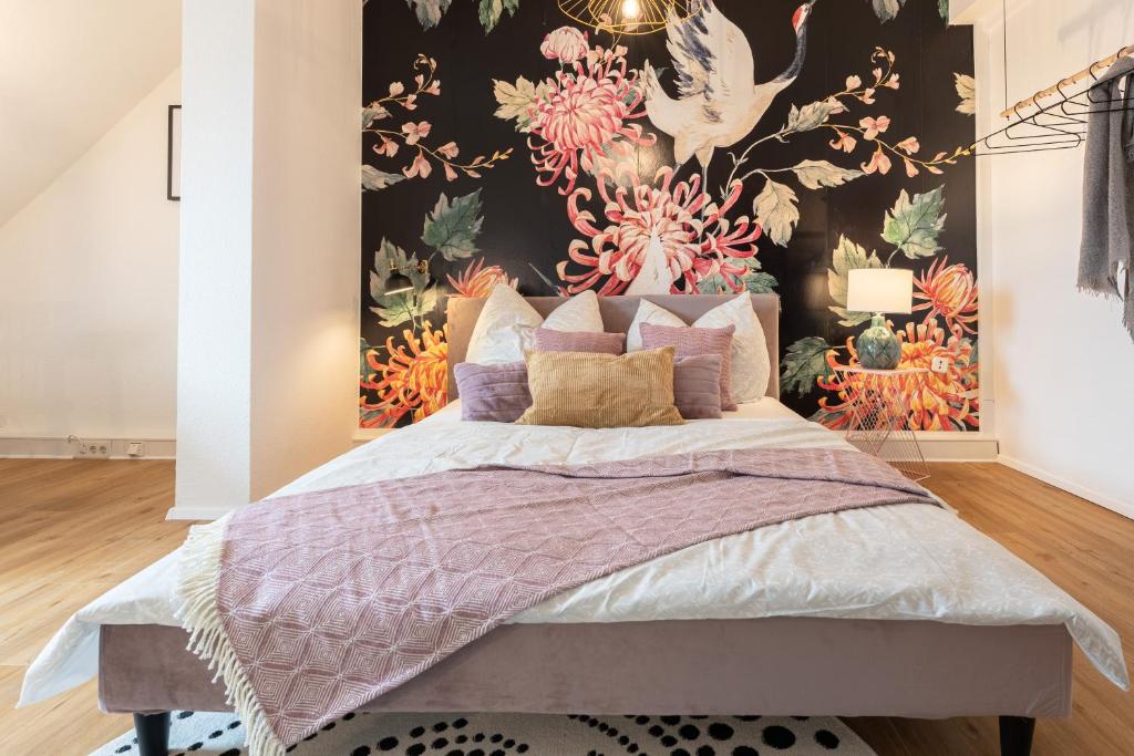 - une chambre avec un grand lit et du papier peint floral dans l'établissement Design Apartment Zentral & Rooms - Toplage am Opernhaus, à Nuremberg