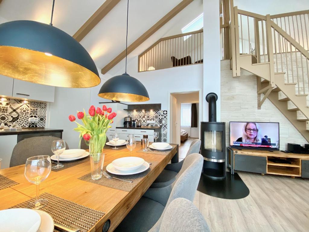 a dining room with a table and a tv at mönchgut living & spa in Gager