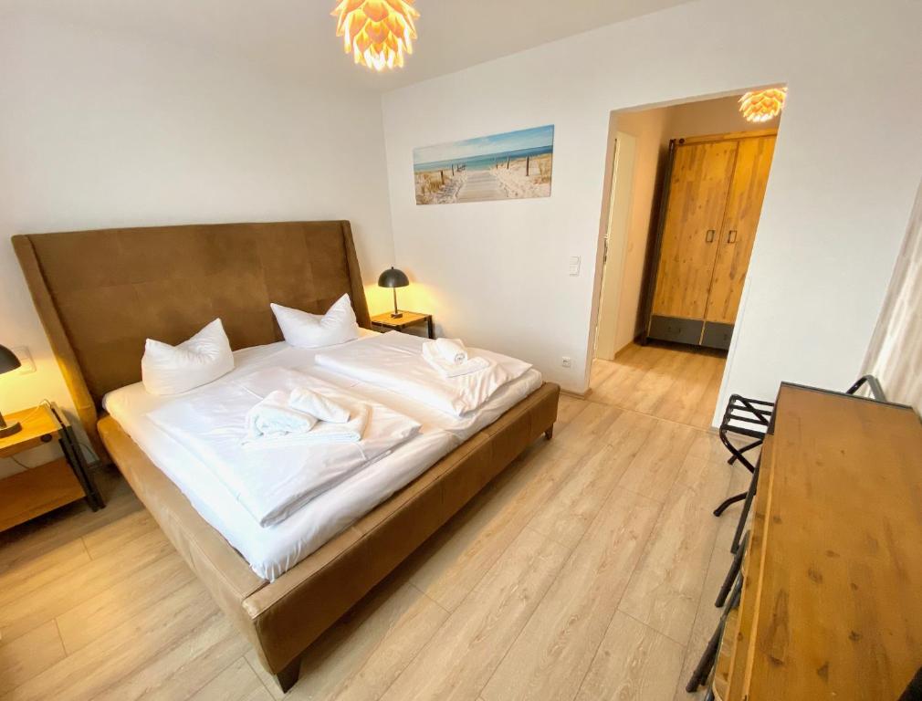a bedroom with a large bed with white sheets at mönchgut living & spa in Gager
