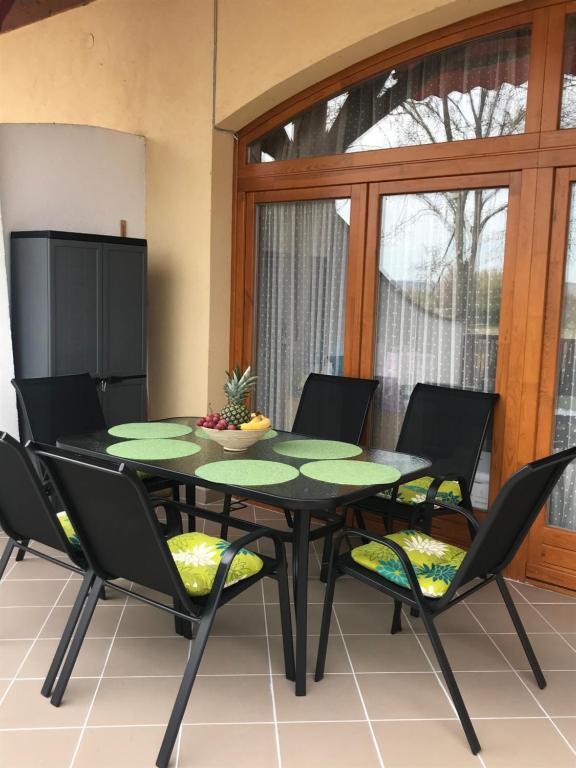 uma sala de jantar com uma mesa preta e cadeiras em Bremi Apartman Fonyódliget em Fonyód