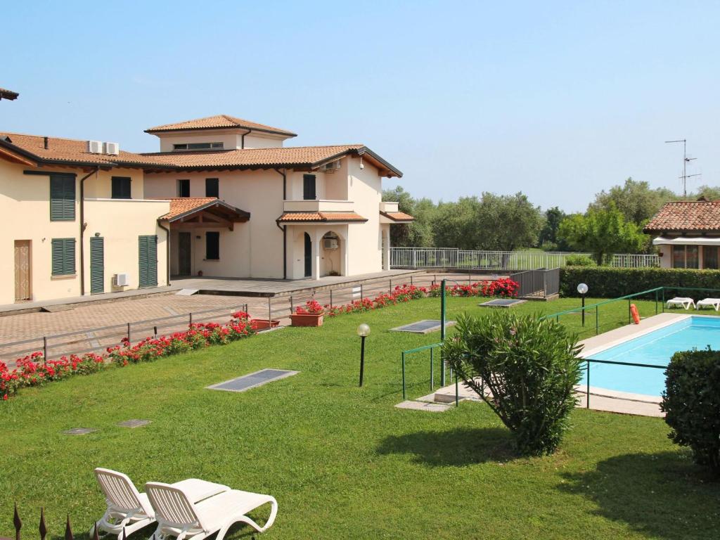 a house with a yard with a swimming pool at Apartment Colombaro Nuovo-5 by Interhome in San Felice del Benaco