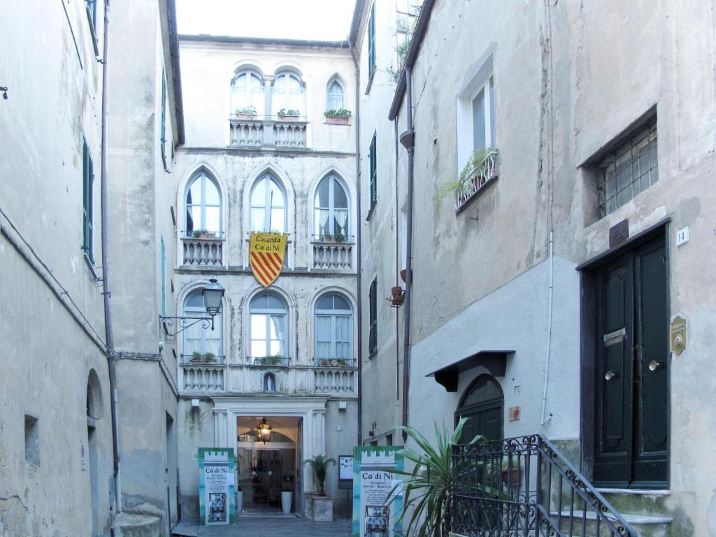 un vicolo tra due edifici con un edificio con balconi di Apartment Merlino - FLG207 by Interhome a Finale Ligure