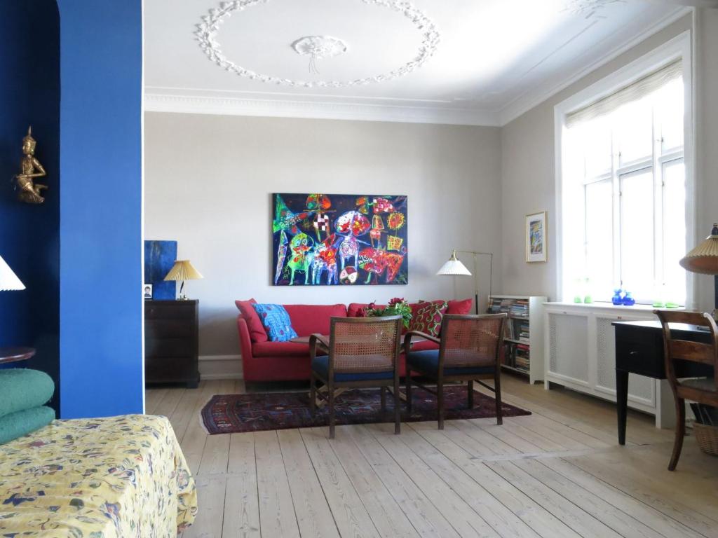 un soggiorno con divano rosso e sedie di ApartmentInCopenhagen Apartment 1150 a Copenaghen